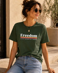 May include: A dark olive green short-sleeve t-shirt featuring the white text Freedom followed by a horizontal striped graphic in yellow, orange, and red, with the additional white text IS MY FAVORITE F-WORD printed underneath.